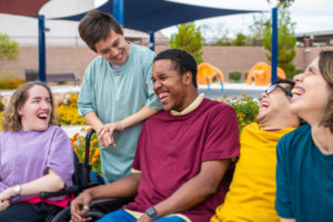 A group of people with disabilities laughing at an outdoor recreation center.