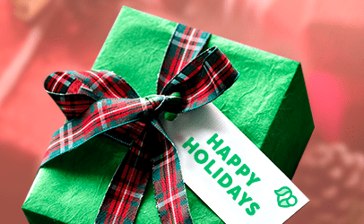Image of a green Christmas package with a bow. Has a gift tag that reads Happy Holidays.