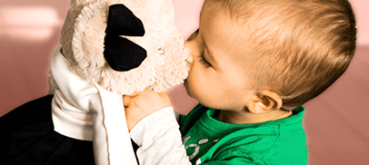 Kid playing with a stuffed bear toy