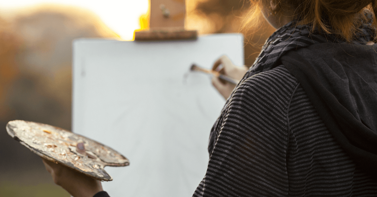 close up view of girl painting on an easel