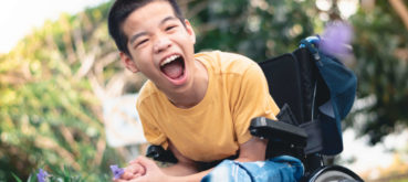 A boy in a wheelchair smiles