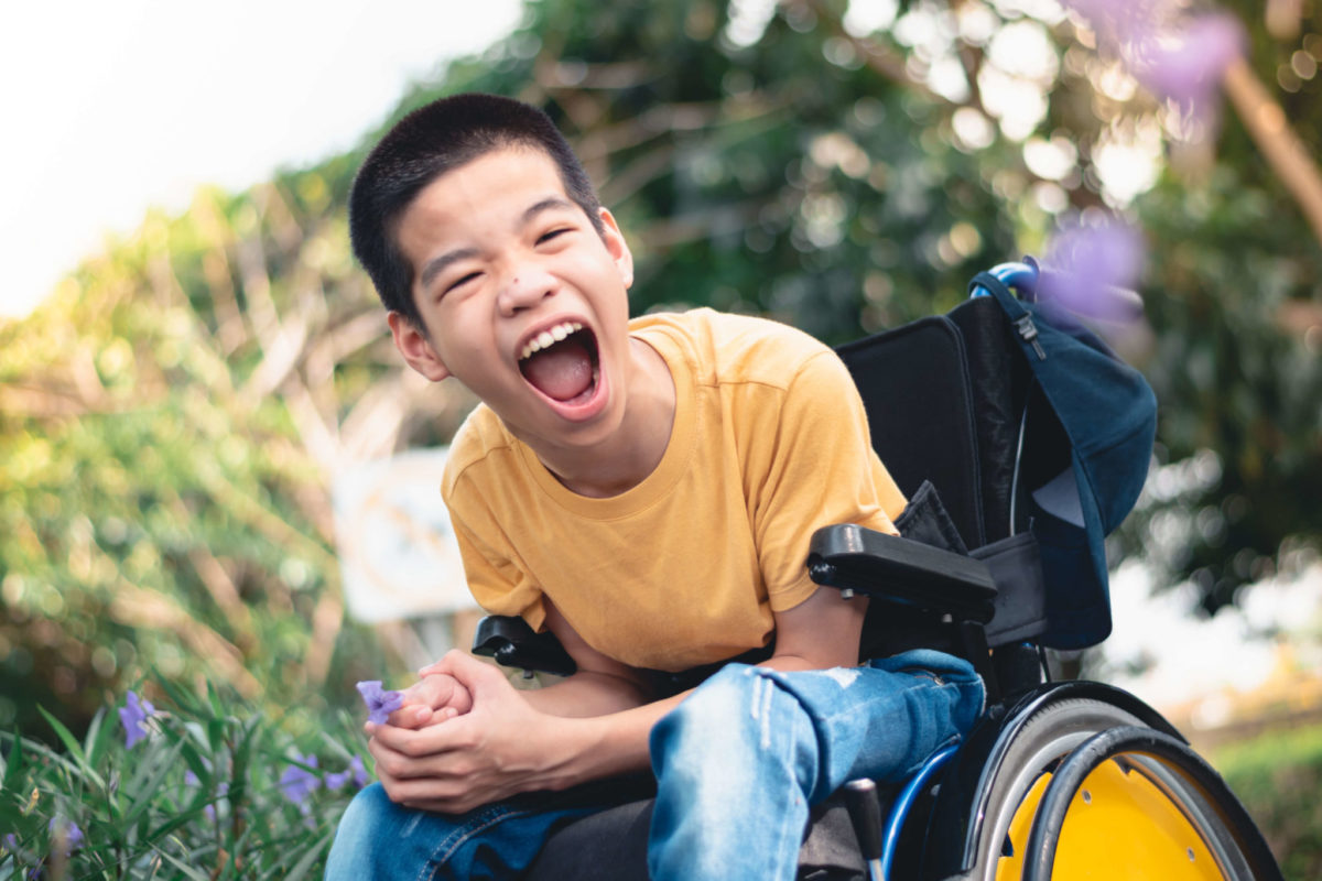 A boy in a wheelchair smiles