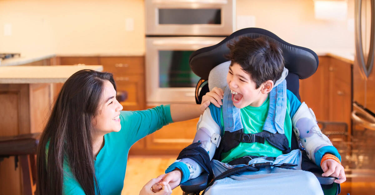 a happy boy with cerebral palsy and his mom