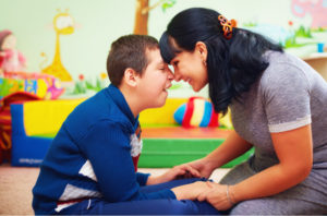 A caregiver interacts with a child with cerebral palsy in an educational setting 