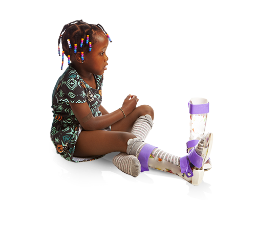 A young girl with cerebral palsy sits with one leg brace on, and one leg brace beside her