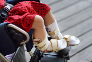 young girl in leg braces in a wheelchair, due to her cerebral palsy