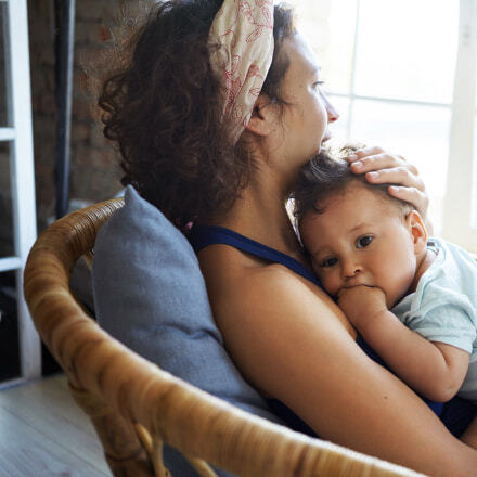 A women sits in a chair hugging a baby