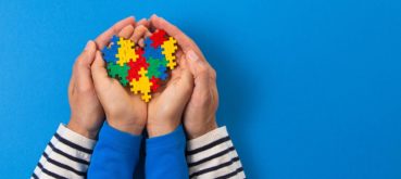 Child and parent holding a handful of puzzle pieces.