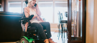 Person in wheelchair smiles on the phone