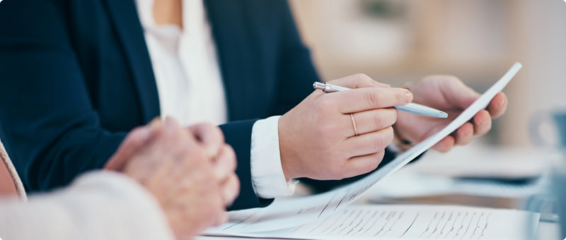 Close-up of a lawyer and client reviewing birth injury settlement documents together.