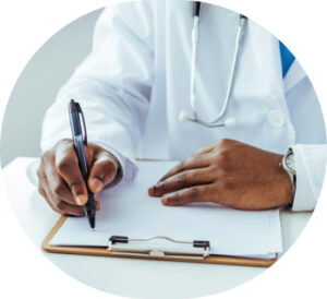 A doctor wearing a stethoscope makes notes on a clipboard filled with paperwork.