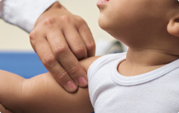 A medical professional examines a child's shoulder for a brachial plexus birth injury.