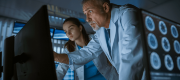 Doctors reviewing brain scans on computer screens, analyzing neurological imaging in a clinical setting.