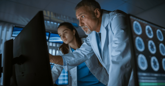 Doctors reviewing brain scans on computer screens, analyzing neurological imaging in a clinical setting.
