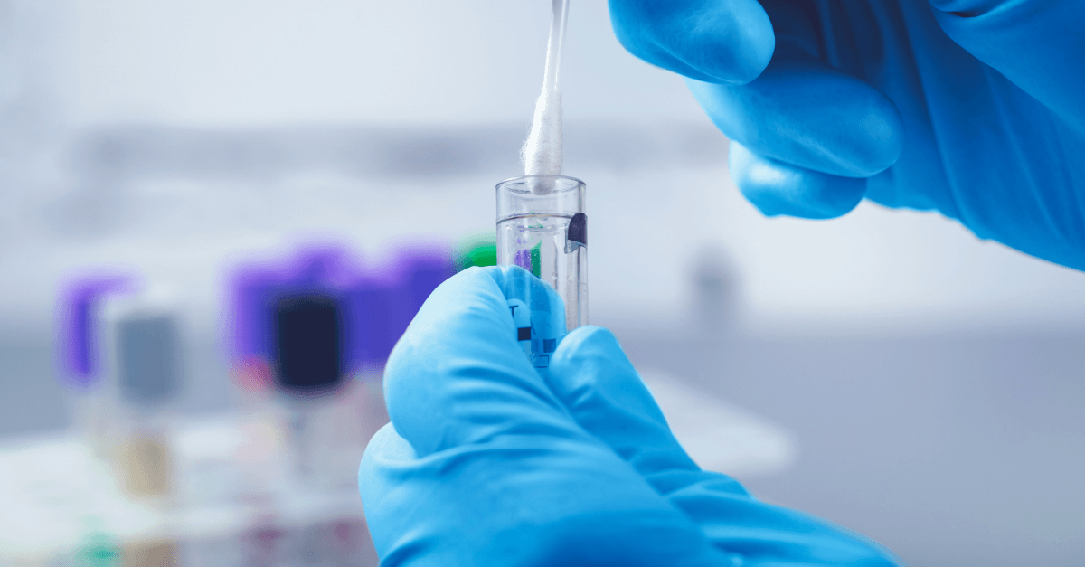 Gloved hands prepare a sample for genetic testing in a laboratory.